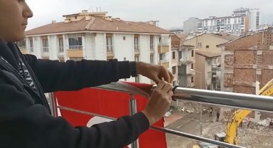 Yerdeki Türk bayrağını önce kaldırıp öptü, ardından yıkayıp balkona astı
