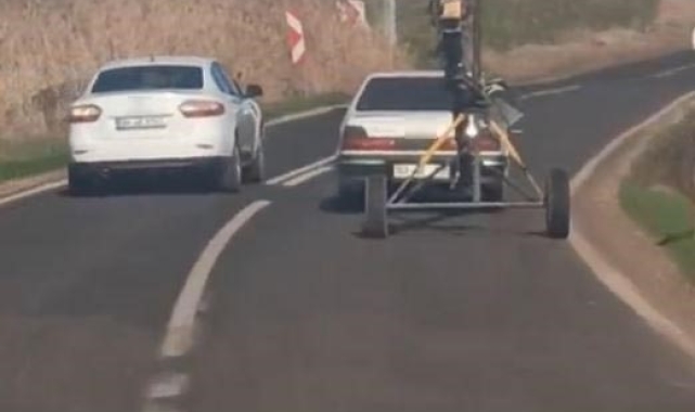 Traktörlerle çekilen helezon makinesini otomobile bağlayarak çekti