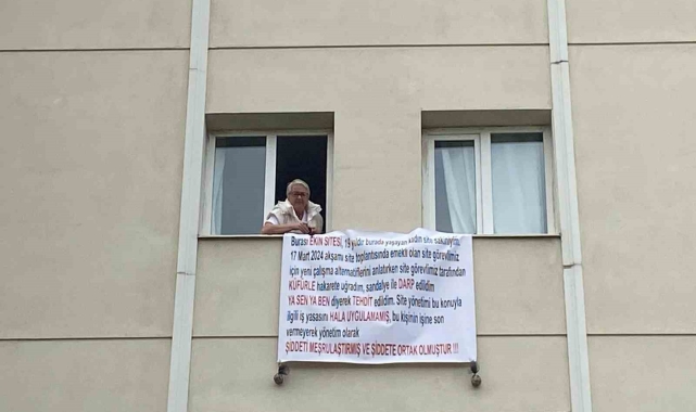 Sandalyeyle darbedilen site sakini, mağduriyetini pankartla dile getirdi