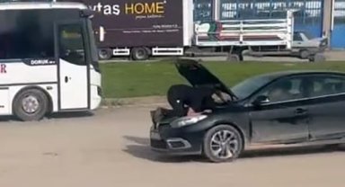 Seyir halindeki otomobilin motoruna oturdu, arızayı bulmaya çalıştı