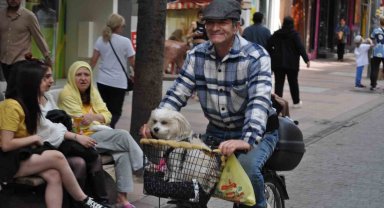 Köpeğini bisikletinin sepetine koyup güzel havanın tadını çıkardı