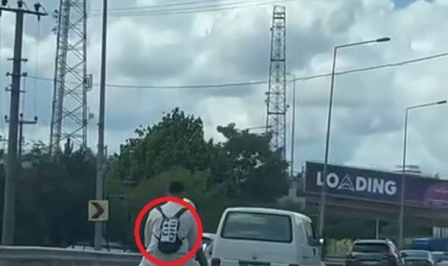 Ceza yememek için düşen plakasını sırt çantasına yapıştırdı