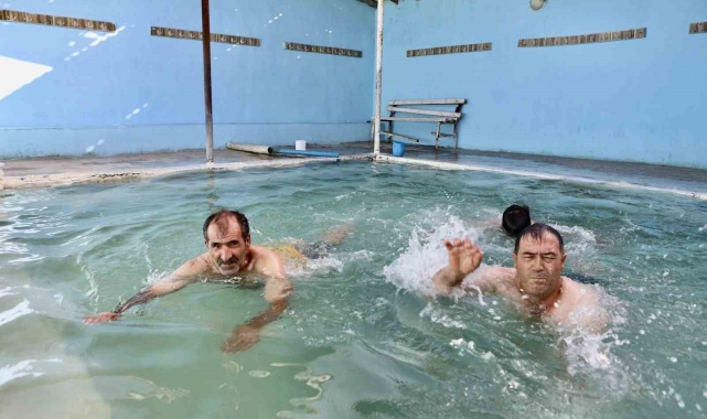 Kavurucu sıcaklarda 50 dereceyi bulan suya girerek şifa arıyorlar