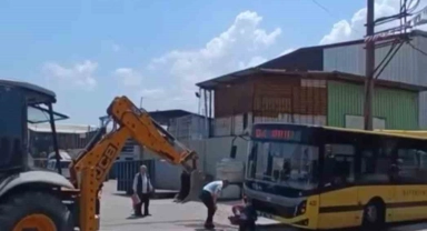 Kazı çalışması yapılan yerden geçmeye çalışan otobüs asılı kaldı