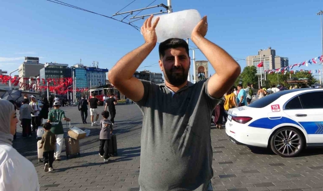 Taksim'de sıcaktan bunalan simit satıcısı buz kalıbıyla serinledi
