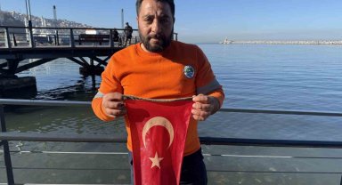 Belediye personeli denize düşen Türk bayrağı için buz gibi suya girdi