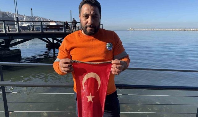 Belediye personeli denize düşen Türk bayrağı için buz gibi suya girdi