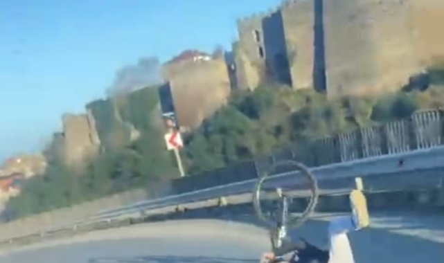 Bisikleti ile tek teker üzerine yolda gitmeye çalışırken az kalsın otomobilin altında kalıyordu