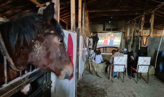 Çocukların at çiftliğinde saman balyaları üstünde sinema keyfi