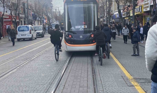 Tramvayın arkasına tutunan bisikletli çocuklar canlarını tehlikeye attı