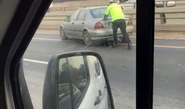 Yardımsever polis arızalanan aracın arkasına geçerek yol kenarına itti