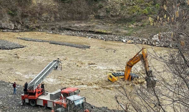 Çayın debisi yükselince iş makinesinin üzerinde mahsur kaldı