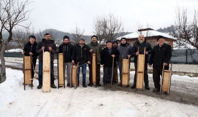 Karlı zemini traktörle pist yapıp geleneksel kızaklarla eğleniyorlar