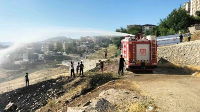 İtfaiyeciler yangın söndürme derdinde, çocuklar serinlemenin keyfinde