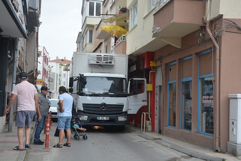 HATALI PARK YÜZÜNDEN YOLDA İLERLEYEMEYEN KAMYON BALKON ALTINA SIKIŞTI